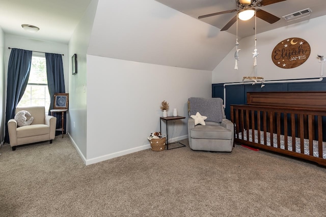 bedroom with carpet, a crib, vaulted ceiling, baseboards, and ceiling fan
