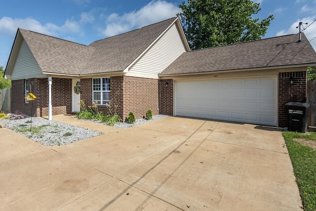 view of front facade featuring brick siding, a shingled roof, and driveway