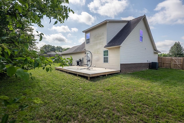 rear view of house featuring a wooden deck, a shingled roof, and cooling unit