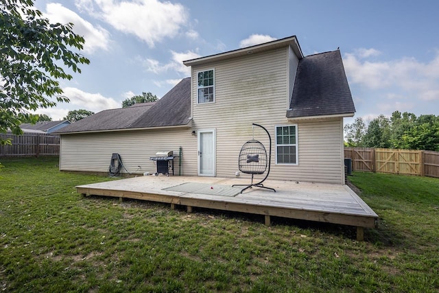 back of property with roof with shingles, a wooden deck, and central AC