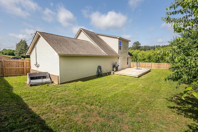 rear view of house featuring a wooden deck and roof with shingles