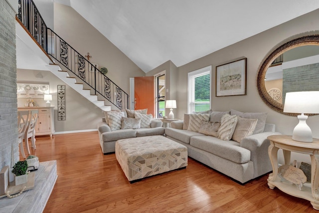6331 Twin Oaks Dr, Millington, TN 38053 - living area featuring wood finished floors, high vaulted ceiling, stairs, and baseboards