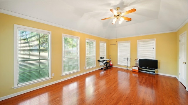 living room with a ceiling fan, wood finished floors, baseboards, and ornamental molding