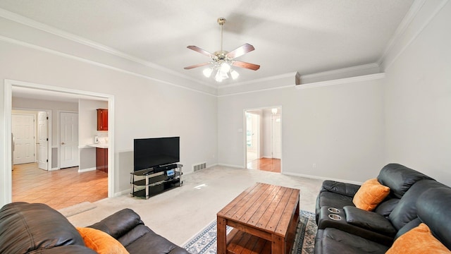 living area featuring a ceiling fan, ornamental molding, light carpet, and baseboards