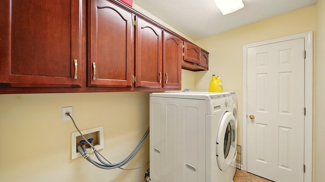 washroom featuring washer / dryer, cabinet space, and light tile patterned flooring