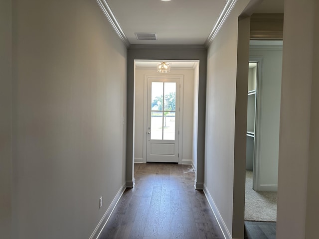 doorway to outside featuring crown molding, dark wood-type flooring, and baseboards