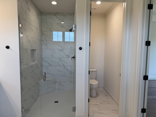 bathroom featuring marble finish floors, baseboards, a stall shower, toilet, and ornamental molding