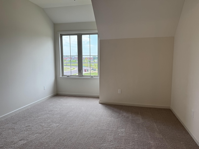 bonus room featuring lofted ceiling, carpet flooring, and baseboards