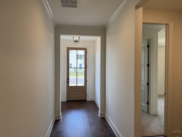 doorway with crown molding, dark wood-style flooring, and baseboards