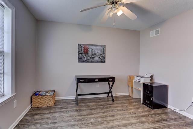 home office with wood finished floors, a ceiling fan, and baseboards