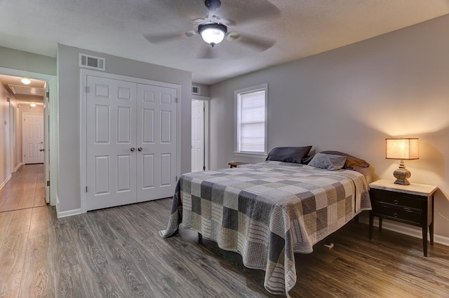bedroom with wood finished floors, baseboards, a closet, a ceiling fan, and a textured ceiling