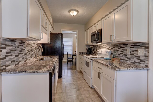 kitchen with white electric stove, stainless steel microwave, a sink, tasteful backsplash, and a textured ceiling
