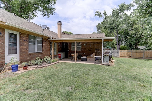 back of house with a patio, brick siding, a chimney, and roof with shingles