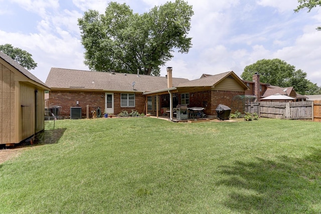 back of house with a patio area, brick siding, central AC, and a shingled roof