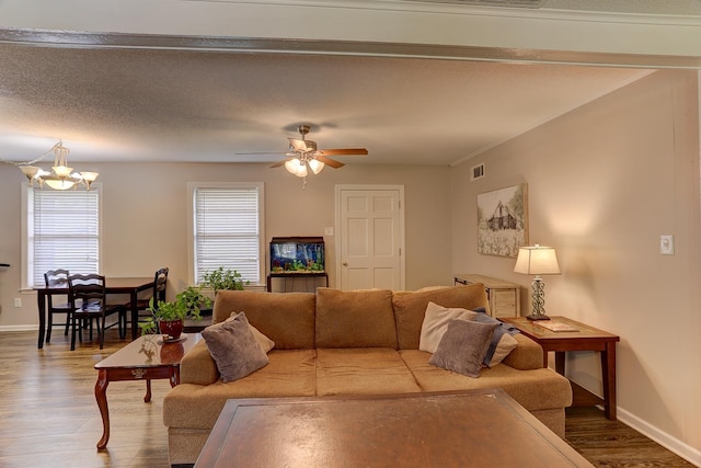 living area with wood finished floors, baseboards, a chandelier, and a ceiling fan