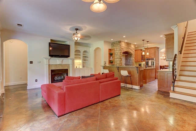 100 Whitehall Ct, Unicorp/Eads, TN 38028 - living room with ornamental molding, a tile fireplace, arched walkways, stairway, and built in features