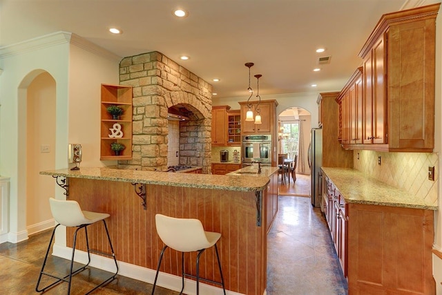 100 Whitehall Ct, Unicorp/Eads, TN 38028 - kitchen featuring arched walkways, stainless steel appliances, ornamental molding, brown cabinets, and a peninsula