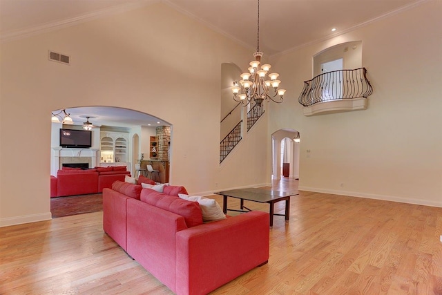 100 Whitehall Ct, Unicorp/Eads, TN 38028 - living room with arched walkways, a high ceiling, a chandelier, a fireplace, and stairs