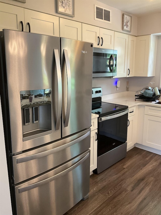 6288 Martinwest Dr, Millington, TN 38053 - kitchen featuring stainless steel appliances, dark wood-type flooring, light countertops, and white cabinets