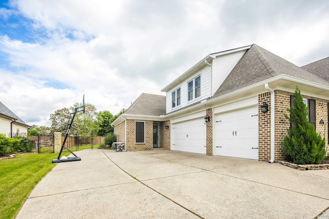 view of property exterior featuring brick siding, concrete driveway, fence, and roof with shingles