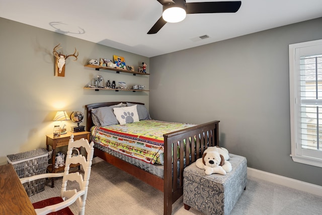 carpeted bedroom featuring multiple windows, a ceiling fan, and baseboards