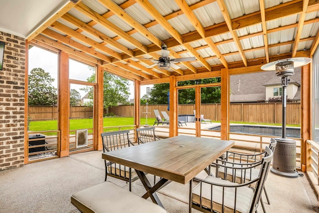 sunroom featuring a ceiling fan and outdoor dining space