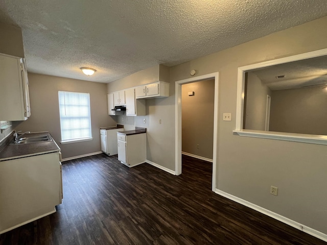 4034 Edgehill St, Memphis, TN 38128 - kitchen with a sink, a textured ceiling, white cabinetry, dark wood-type flooring, and baseboards