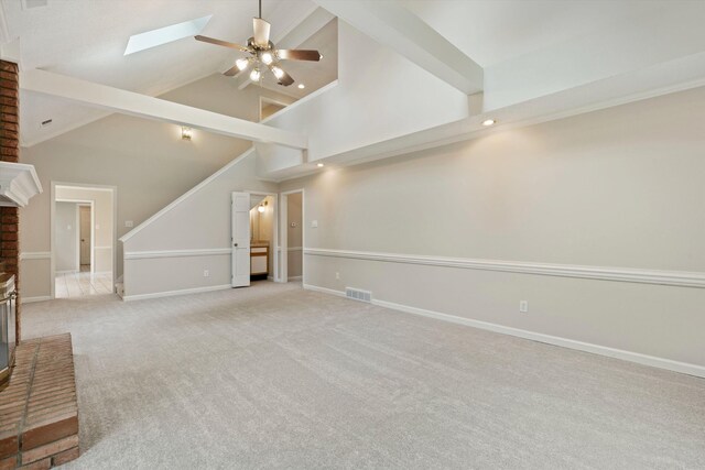 8450 Stoksund Cv, Memphis, TN 38018 - unfurnished living room featuring ceiling fan, baseboards, carpet, a skylight, and high vaulted ceiling