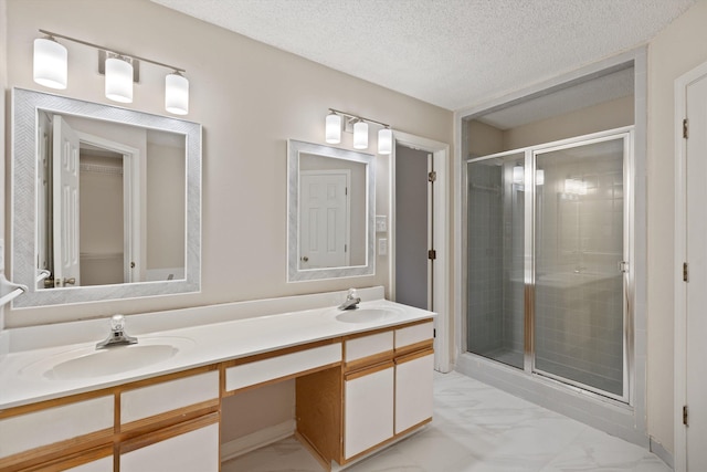 full bathroom featuring a shower stall, double vanity, marble finish floors, and a textured ceiling