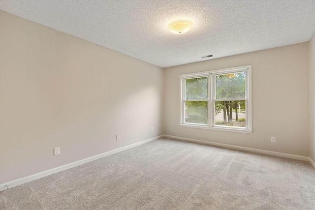 unfurnished room featuring a textured ceiling, carpet floors, and baseboards