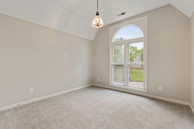 carpeted empty room with vaulted ceiling and baseboards