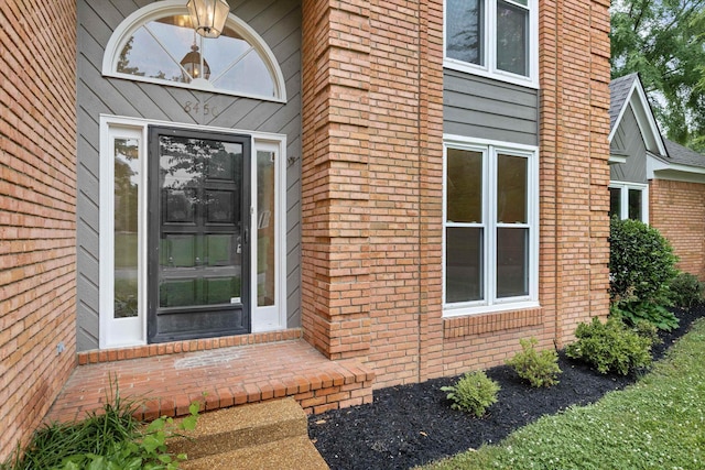 view of exterior entry with brick siding