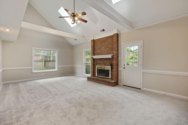 unfurnished living room featuring a skylight, healthy amount of natural light, a ceiling fan, a brick fireplace, and high vaulted ceiling