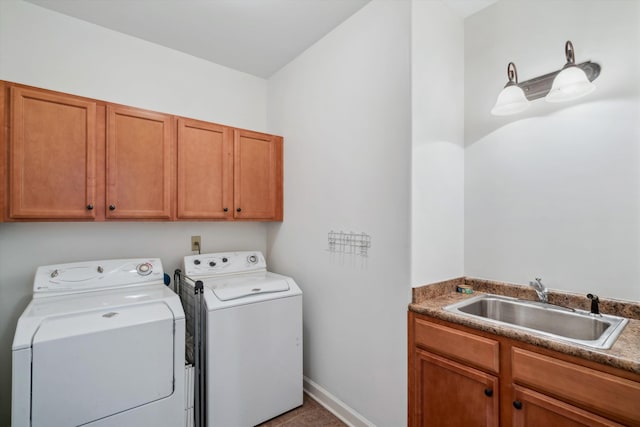 washroom with washer and dryer, cabinet space, and baseboards