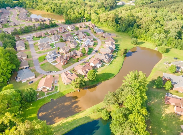 aerial view of property's location with a large body of water, a forest, and nearby suburban area