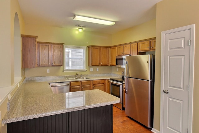 1354 E Island Pl, Memphis, TN 38103 - kitchen featuring stainless steel appliances, a sink, a peninsula, light wood-style floors, and light countertops