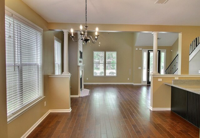 1354 E Island Pl, Memphis, TN 38103 - unfurnished dining area with decorative columns, healthy amount of natural light, and dark wood finished floors