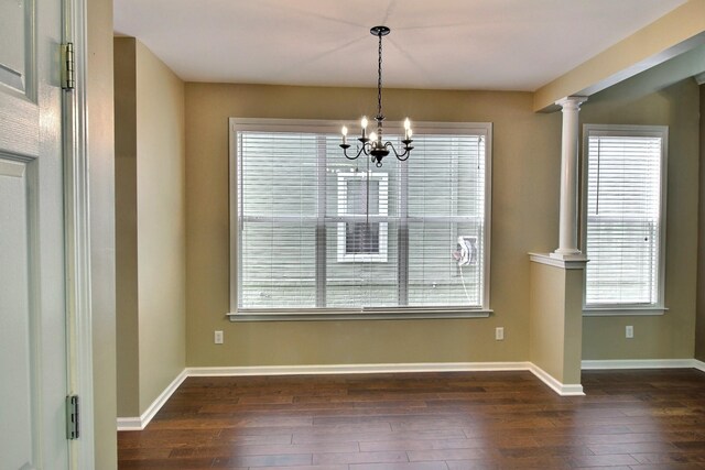 1354 E Island Pl, Memphis, TN 38103 - unfurnished dining area with a chandelier, dark wood-style flooring, baseboards, and ornate columns