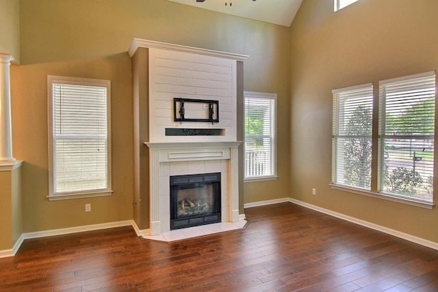 1354 E Island Pl, Memphis, TN 38103 - unfurnished living room featuring hardwood / wood-style floors, a tiled fireplace, plenty of natural light, and vaulted ceiling