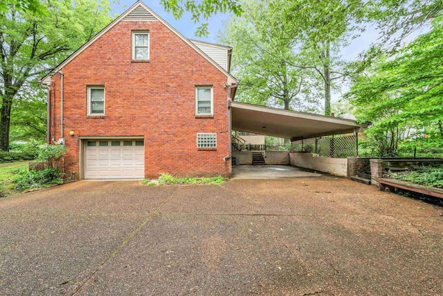 6196 Ivanhoe Cv, Bartlett, TN 38134 - view of home's exterior featuring asphalt driveway, an attached garage, a carport, and brick siding