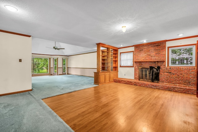 6196 Ivanhoe Cv, Bartlett, TN 38134 - unfurnished living room featuring a brick fireplace, plenty of natural light, a textured ceiling, ceiling fan, and baseboards
