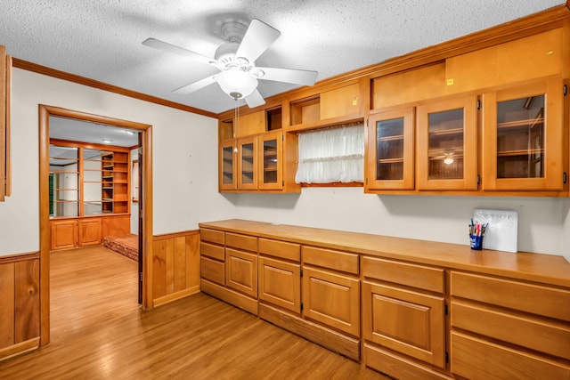 6196 Ivanhoe Cv, Bartlett, TN 38134 - kitchen featuring a textured ceiling, a wainscoted wall, light wood-style floors, light countertops, and ornamental molding