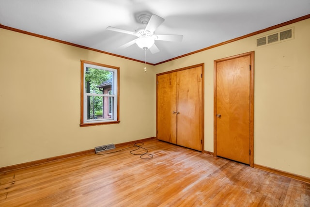 6196 Ivanhoe Cv, Bartlett, TN 38134 - unfurnished bedroom with wood finished floors, two closets, baseboards, crown molding, and a ceiling fan