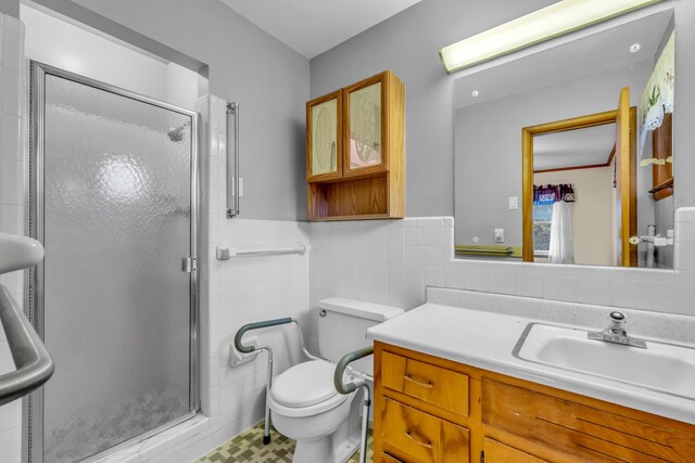 6196 Ivanhoe Cv, Bartlett, TN 38134 - bathroom with tile walls, a shower stall, toilet, a wainscoted wall, and vanity