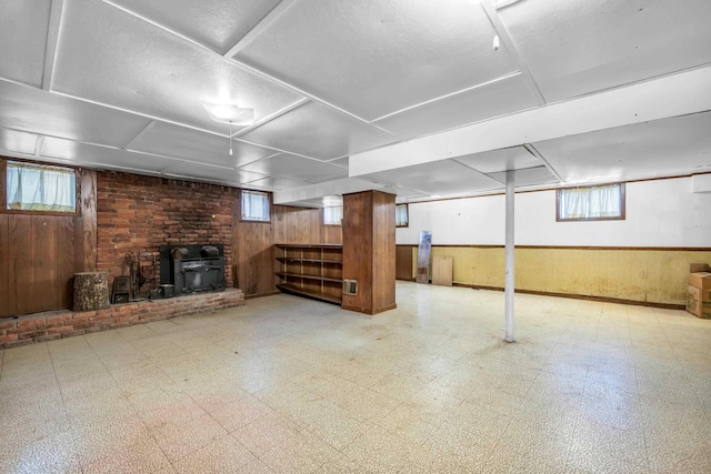 6196 Ivanhoe Cv, Bartlett, TN 38134 - below grade area with tile patterned floors, a wood stove, wood walls, healthy amount of natural light, and wainscoting