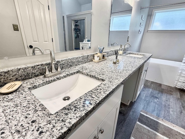 1210 Sanbyrn Dr, Cordova, TN 38018 - full bathroom featuring wood finished floors, double vanity, and a tub to relax in