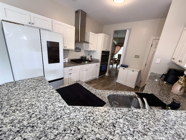 1210 Sanbyrn Dr, Cordova, TN 38018 - kitchen featuring wall chimney range hood, freestanding refrigerator, a sink, stainless steel gas cooktop, and white cabinetry