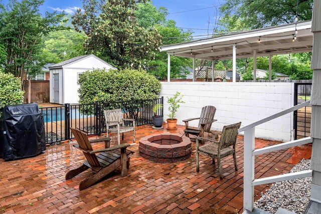 185 Alexander St, Memphis, TN 38111 - view of patio / terrace with an outdoor fire pit, area for grilling, an outbuilding, a storage shed, and a swimming pool