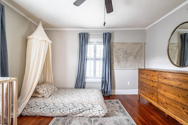 bedroom featuring wood finished floors, ornamental molding, a textured ceiling, baseboards, and a ceiling fan