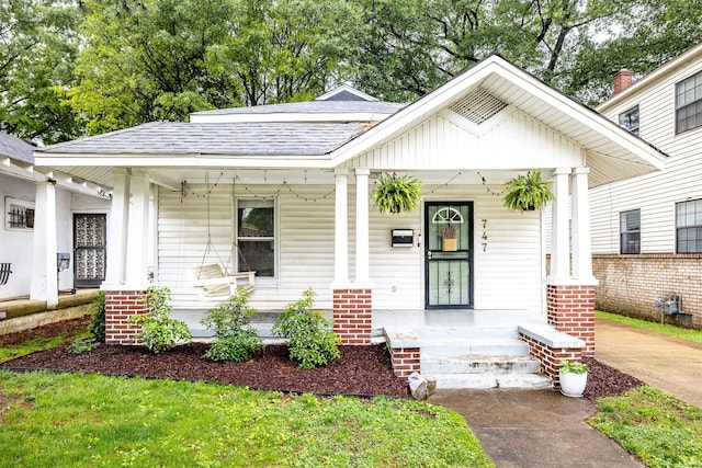 bungalow-style house featuring a porch and roof with shingles